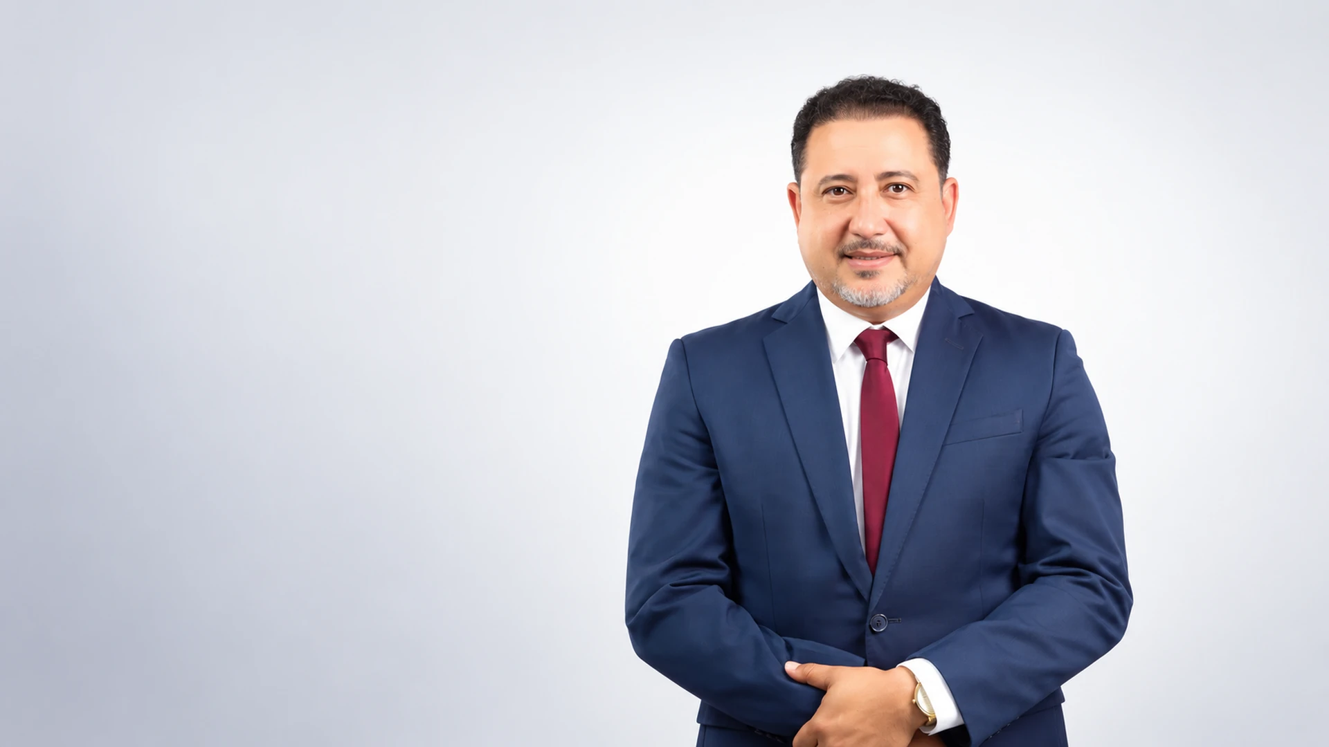 Retrato profesional del Dr. Wilton Cabrera con traje azul sobre fondo claro.